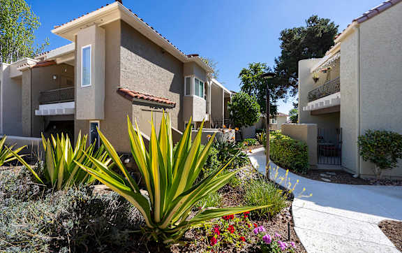Residential walkway with colorful flowering plants and yucca at Bella Del Mar Apartments, Del Mar, CA, 92014