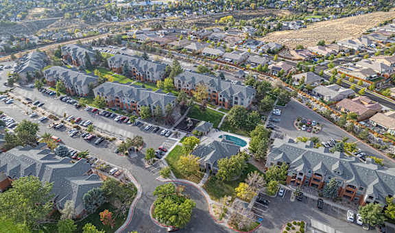 A bird's eye view of a residential area with houses and parked cars.