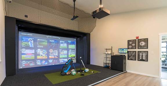 A room with a screen displaying a golf game.