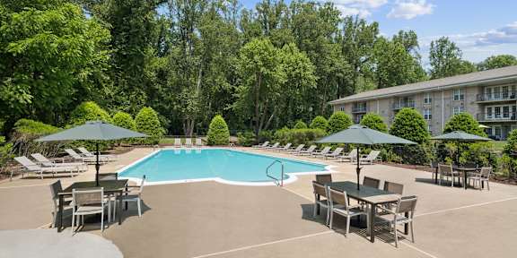 a man and woman sitting at a table with drink at The Overlook at Quantico Apartments, Triangle