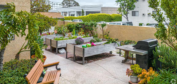a backyard with benches and plants and a grill at Huntington Terrace North Senior, California, 92648
