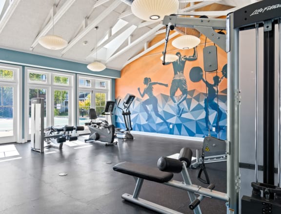 a gym with cardio equipment and a mural on the wall at Rosemont Square Apartments, Massachusetts, 02368