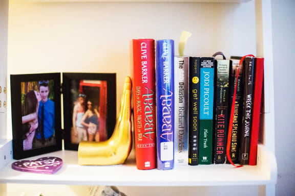 a shelf with books and a banana on it