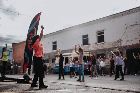 A group of people are dancing in the street.