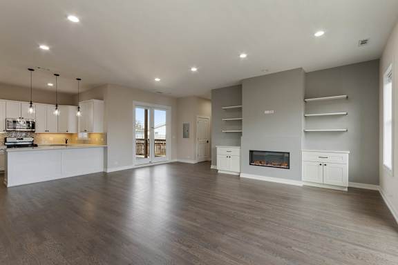 a large living room with a fireplace and a kitchen