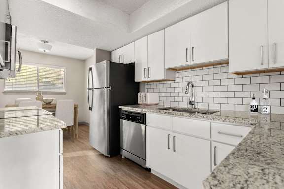 A kitchen with black and white appliances and cabinets.