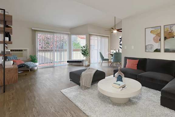 A living room with a black couch, a white coffee table, and a ceiling fan.