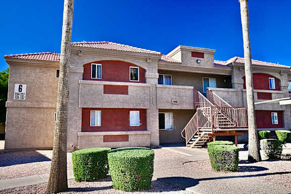 A building with a red roof and a staircase leading to the second floor.