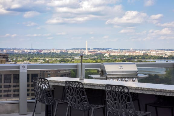 a view of the city from a rooftop bar with a table and chairs at 220 Twentieth Street, Virginia, 22202