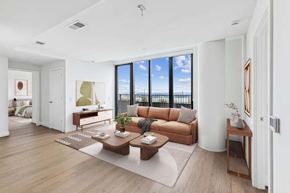 a living room with a couch and a coffee table and a view of the ocean