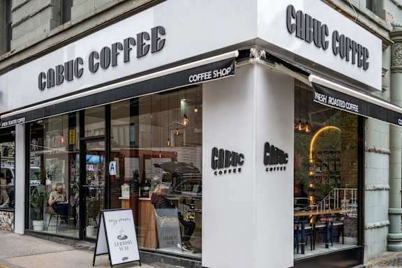 A storefront of a coffee shop named "Cabic Coffee" with a sign offering fresh roasted coffee.