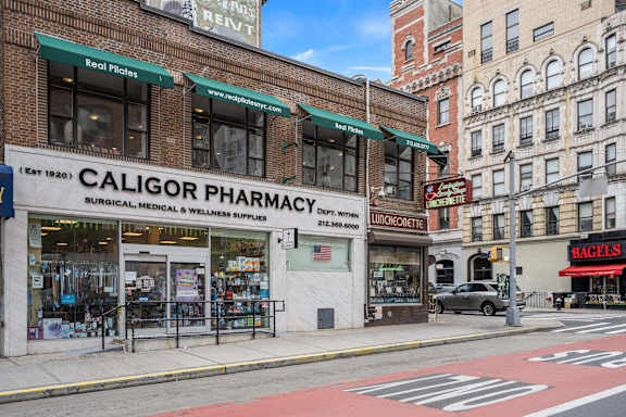 A Caligor Pharmacy is located on the corner of a street.