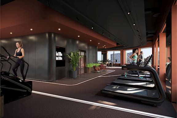 A woman is running on a treadmill in a modern gym.