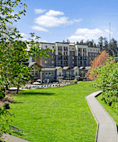 A pathway leads through a grassy area in front of a large building.