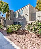 A pathway leads through a landscaped courtyard with a building in the background.