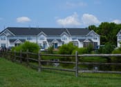 Thumbnail 3 of 3 - a large blue house with a wooden fence in front of it