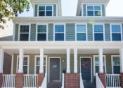Thumbnail 5 of 6 - the front porch of a home with blue shutters and a black door