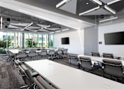 Thumbnail 10 of 12 - A conference room with a long table and chairs.