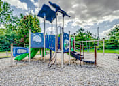 Thumbnail 3 of 6 - A playground with a blue slide, a green slide, and a wooden swing set.