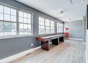 Thumbnail 4 of 7 - A room with a long table and a television on the wall.