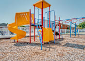 Thumbnail 1 of 7 - A playground with a yellow slide and blue and red structures.