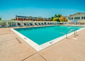 Thumbnail 6 of 7 - A large outdoor swimming pool with a white border and blue water.