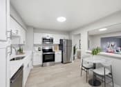 Thumbnail 4 of 5 - A modern kitchen with white cabinets and stainless steel appliances.