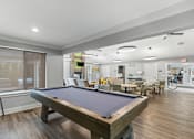Thumbnail 1 of 8 - A pool table is in the middle of a room with a bicycle in the background.