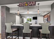 Thumbnail 3 of 8 - A modern bar with striped bar stools and a sign that reads "Tiki Bar".