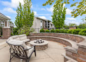 Thumbnail 5 of 8 - A patio with a fire pit and a chair.