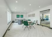 Thumbnail 4 of 6 - A white room with a table and chairs.