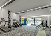 Thumbnail 1 of 6 - A gym with treadmills, elliptical machines, and other exercise equipment.