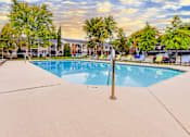 Thumbnail 3 of 6 - A swimming pool surrounded by trees and a fence.