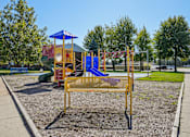Thumbnail 1 of 4 - A playground with a blue and yellow swing set.