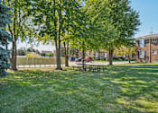 Thumbnail 4 of 4 - A park with a picnic table and trees.