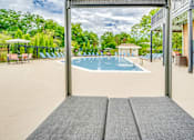 Thumbnail 6 of 6 - A large outdoor swimming pool with a view of the trees.