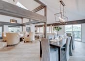 Thumbnail 1 of 6 - A modern dining room with a long table and chairs.