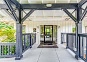 Thumbnail 3 of 6 - A covered walkway with a metal railing and a brown doormat that says "Yale".