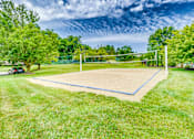 Thumbnail 2 of 6 - A tennis court surrounded by green grass and trees.