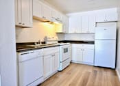 Thumbnail 7 of 8 - A kitchen with white appliances and cabinets.