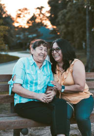 a couple sitting on a park bench at Parkside Apts, Pomona, CA