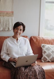 a woman sitting on a couch using a laptop computer