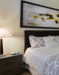 a bedroom with a bed and a painting on the wall  at Pinnacle Apartments, Jacksonville, FL, 32256