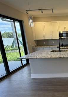 A kitchen with a granite countertop and stainless steel appliances.