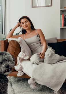 a woman sitting on a couch with her dog