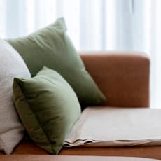 A brown couch with three pillows on it at Seaview Apartments in Staten Island, NY, 10305