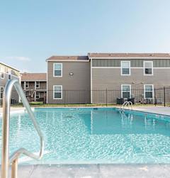 A swimming pool in front of apartment buildings.