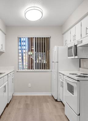 A kitchen with white appliances and cabinets.