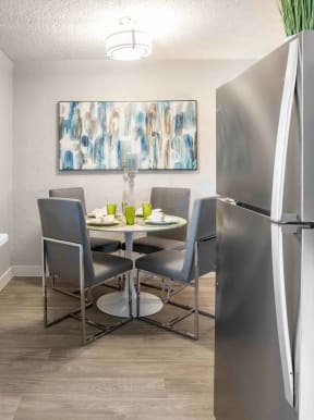 a kitchen and dining room with stainless steel appliances and a table and chairs