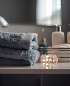 a stack of towels on a table in front of a mirror at Oakwood Manor in Bay Shore, NY 11706
